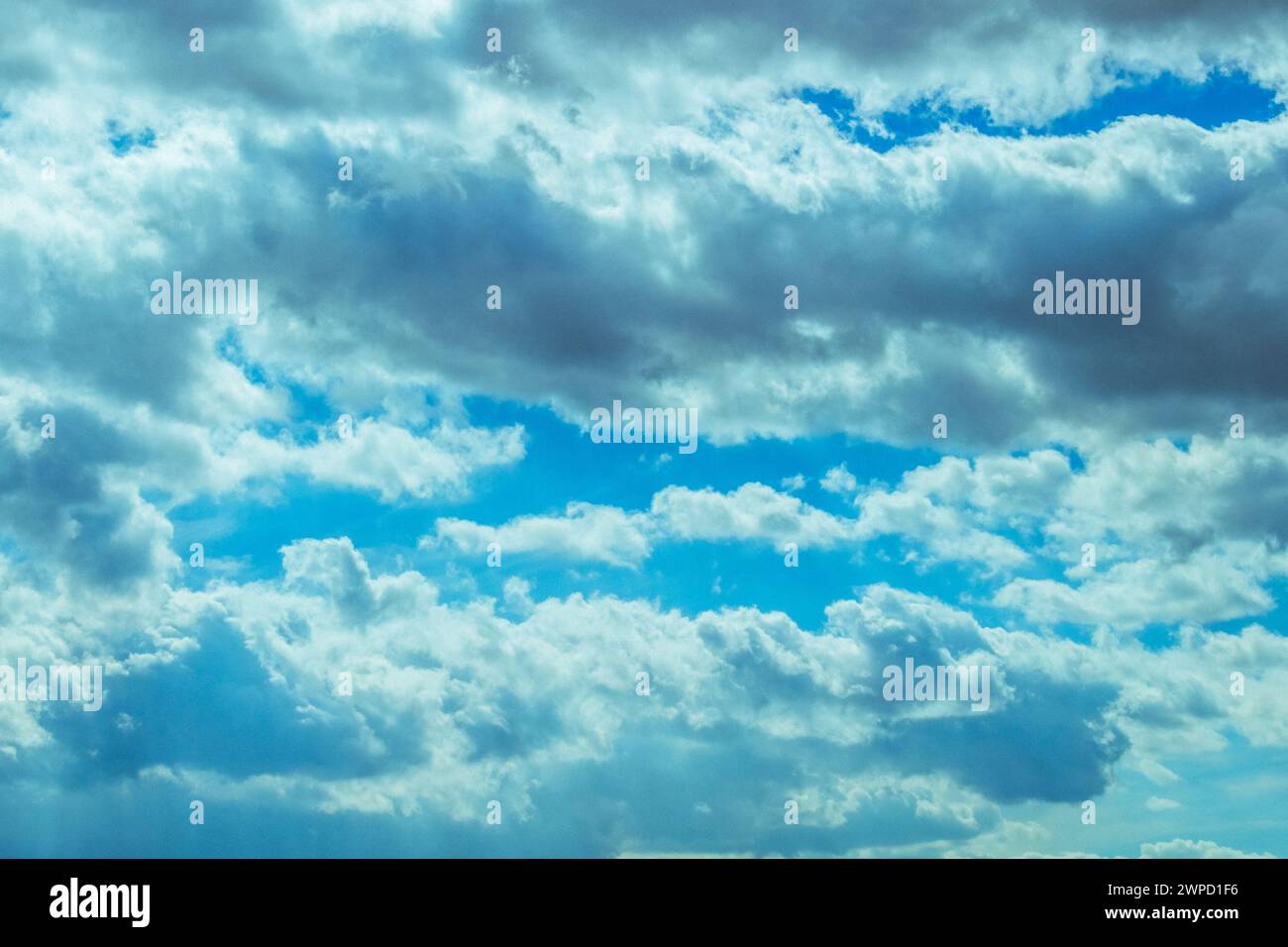 A sky filled with fluffy white clouds against a deep blue background Stock Photo