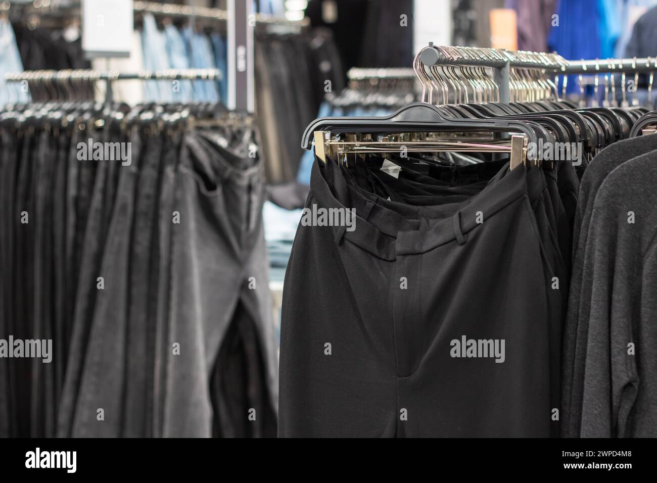 Pants hanging on hangers in a store close up Stock Photo