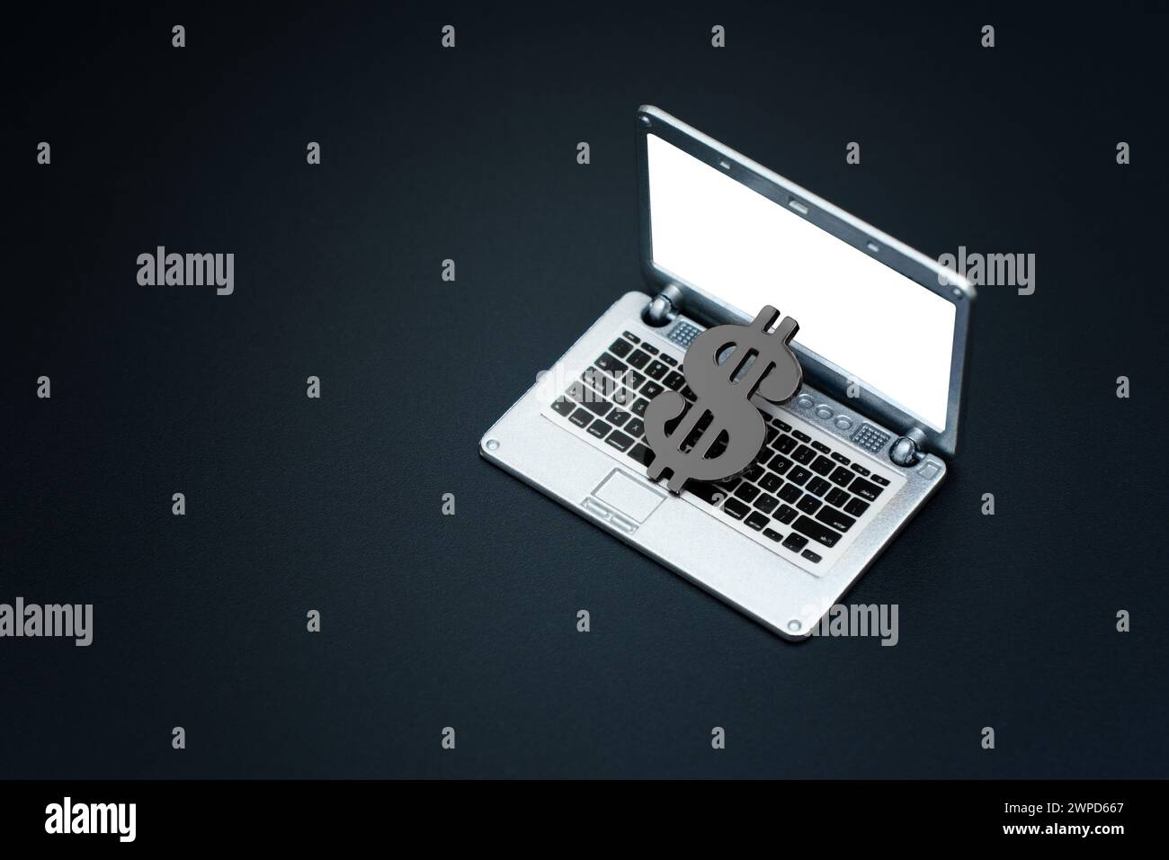 Black dollar sign sprawls across an open miniature laptop. Illicit internet income and dark web related concept. Stock Photo