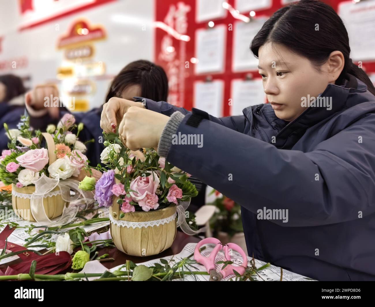 Female employees practice flower arrangement to the