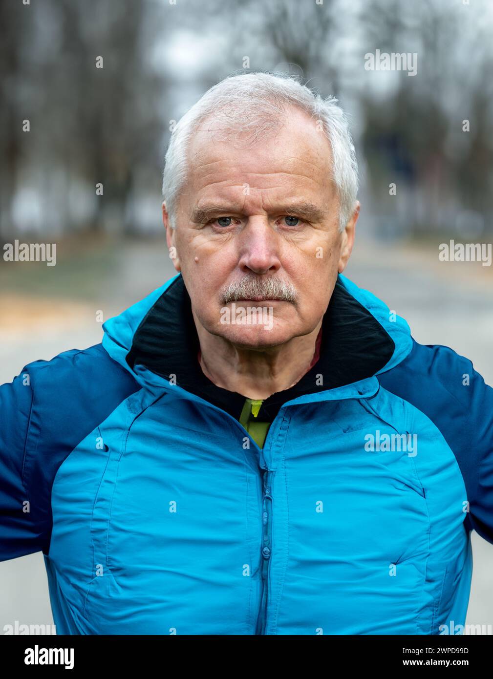 Senior man in sports wear looking into the camera. Symbol for elderly persons being active and doing workouts. Stock Photo
