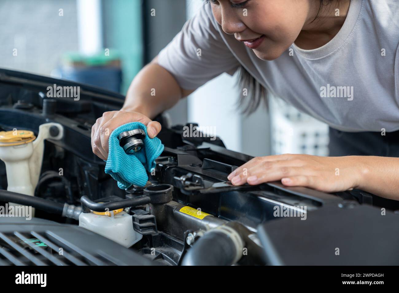 The young woman is opening cooling water, Check open radiator cap Stock