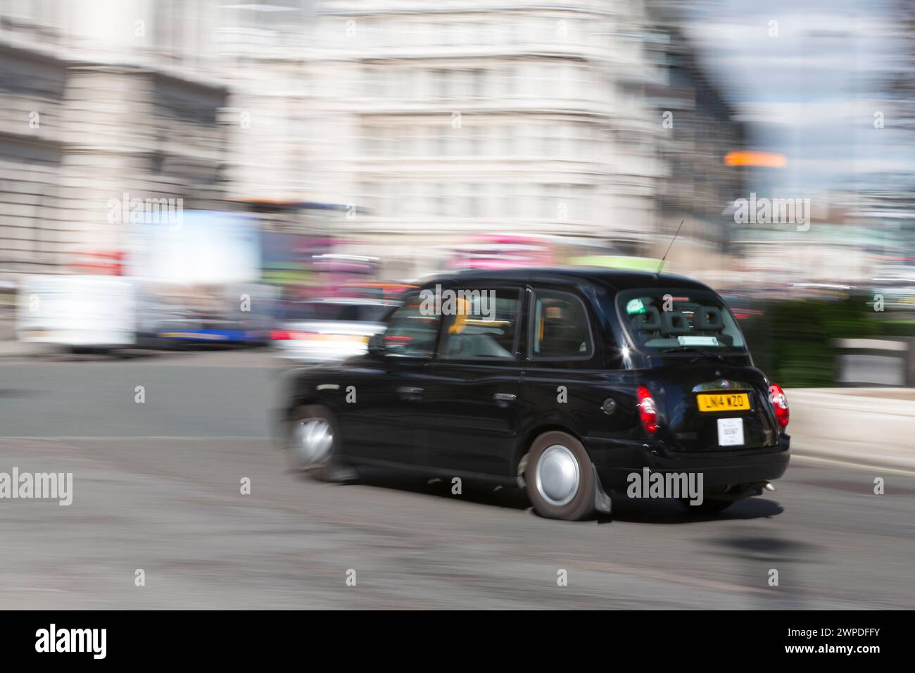 UK, London, Black Taxi cab panned in Parliament square. Stock Photo