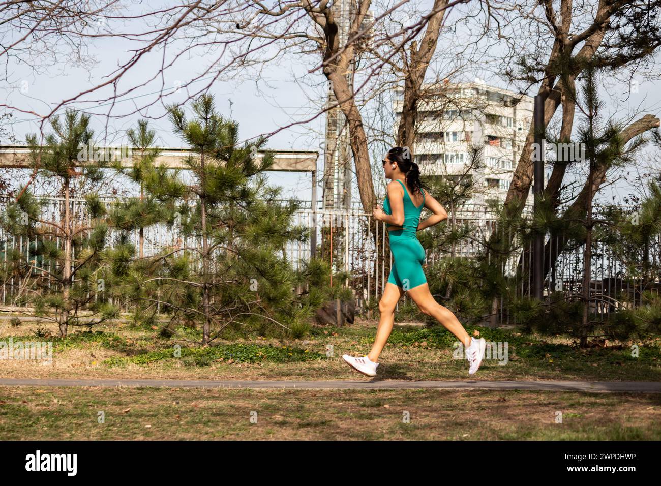 Fit good looking girl jogging in green park in the morning, healthy sporty life, staying active Stock Photo