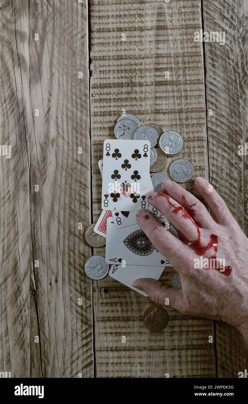 Dead mans hand playing cards aces and eights on wooded background. with Blood stained hand. Stock Photo