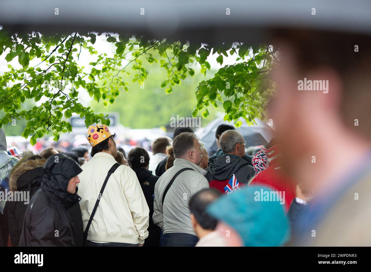 People gather to view the coronation of King Charles III on screen in Hyde Park, London. Stock Photo