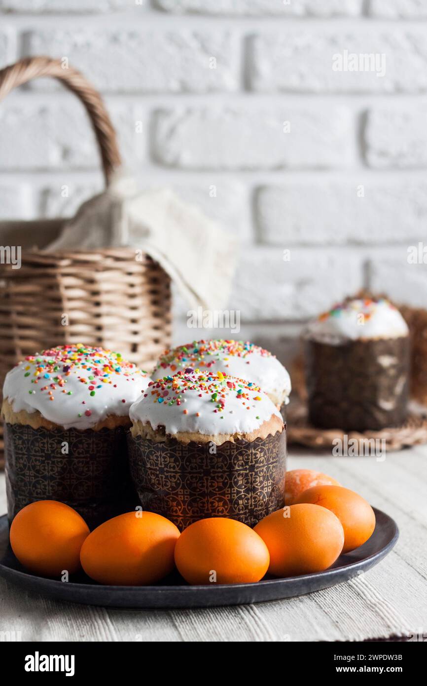 Decorated Easter cakes and yellow colored eggs on a plate. Stock Photo