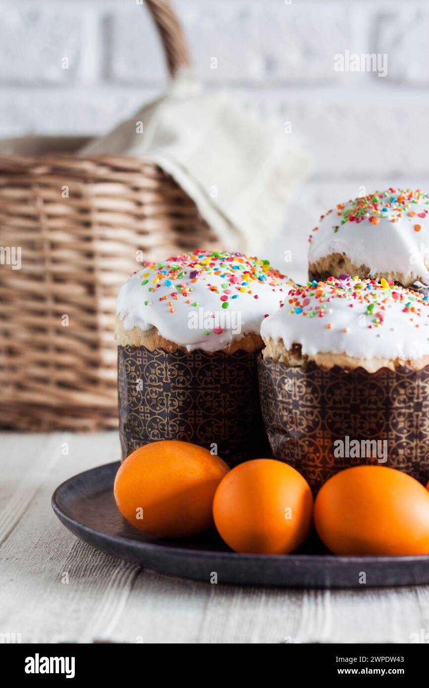 Glaze decorated Easter cakes and yellow colored eggs on a plate. Stock Photo