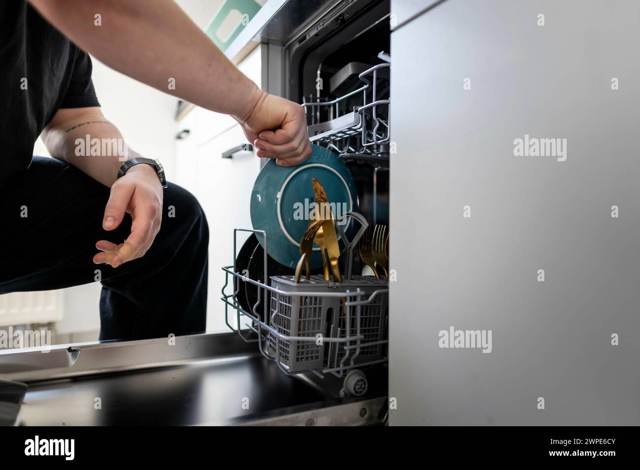 Berlin, Deutschland. 08th Mar, 2024. A man loads a dishwasher. Berlin