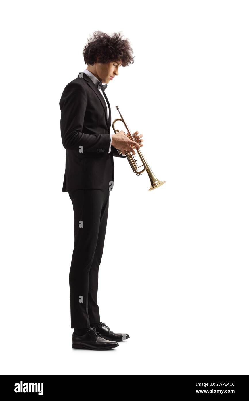Profile shot of a young male musician in a black suit with a trumpet isolated on white background Stock Photo