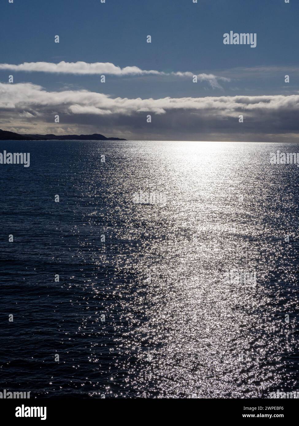 Sunlight reflected off the ocean with Gigha island Scotland, UK. Stock Photo