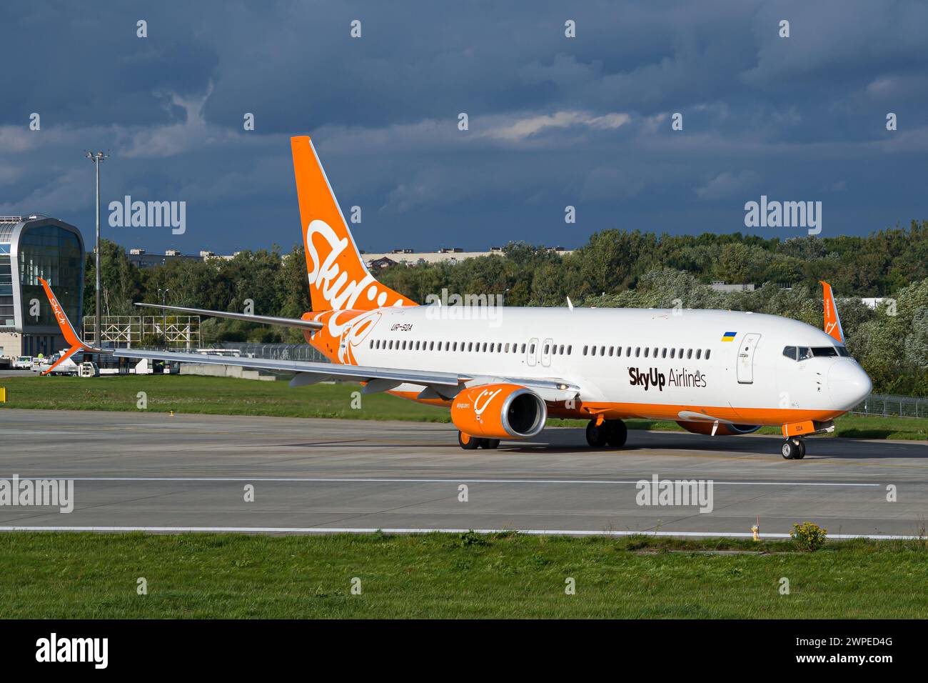 Ukrainian airline's SkyUp Airlines Boeing 737-800 taxiing for takeoff at Lviv Airport with storm clouds in the background Stock Photo