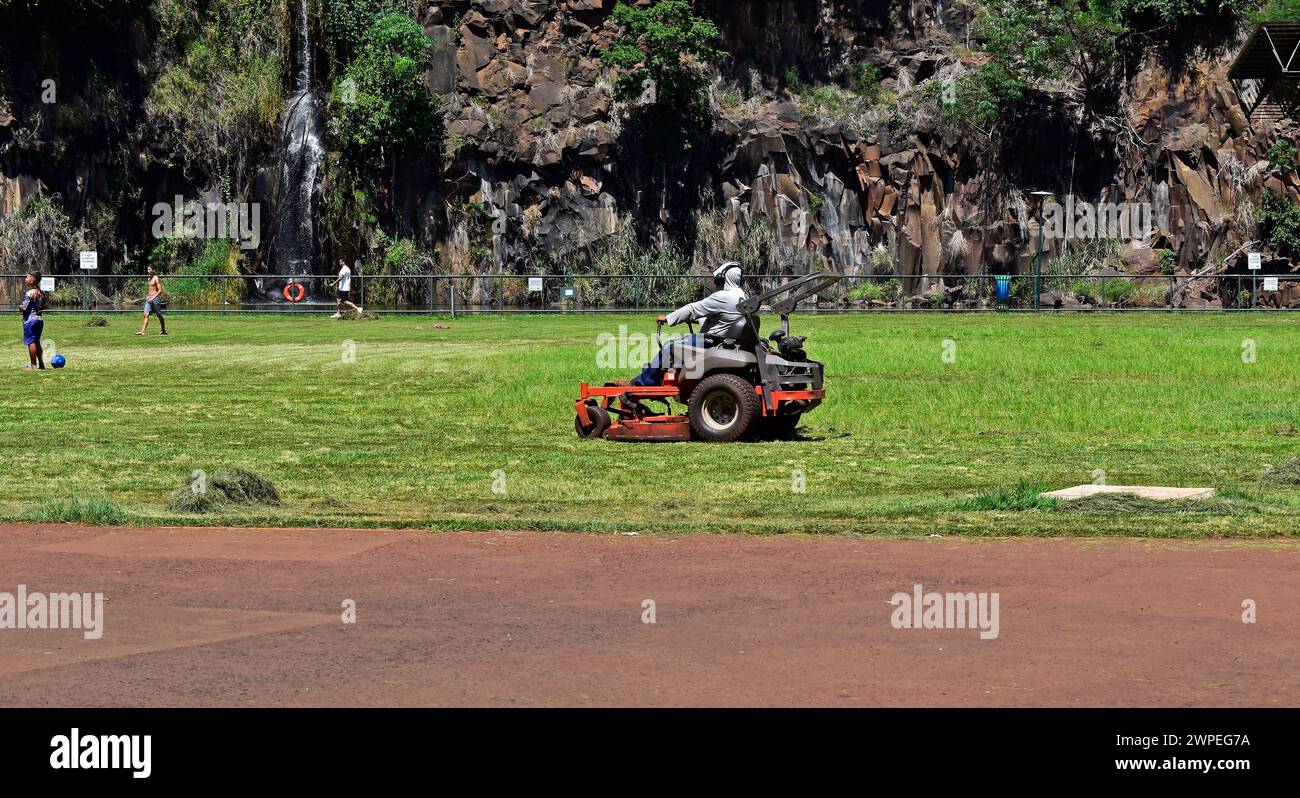 RIBEIRAO PRETO, SAO PAULO, BRAZIL - December 26, 2023: Man mowing the lawn in public park Stock Photo