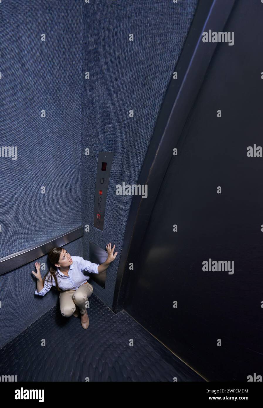 Business, person and fear of elevator with worry for trapped, claustrophobia or anxiety in emergency. Office, lift and woman scared for safety in Stock Photo