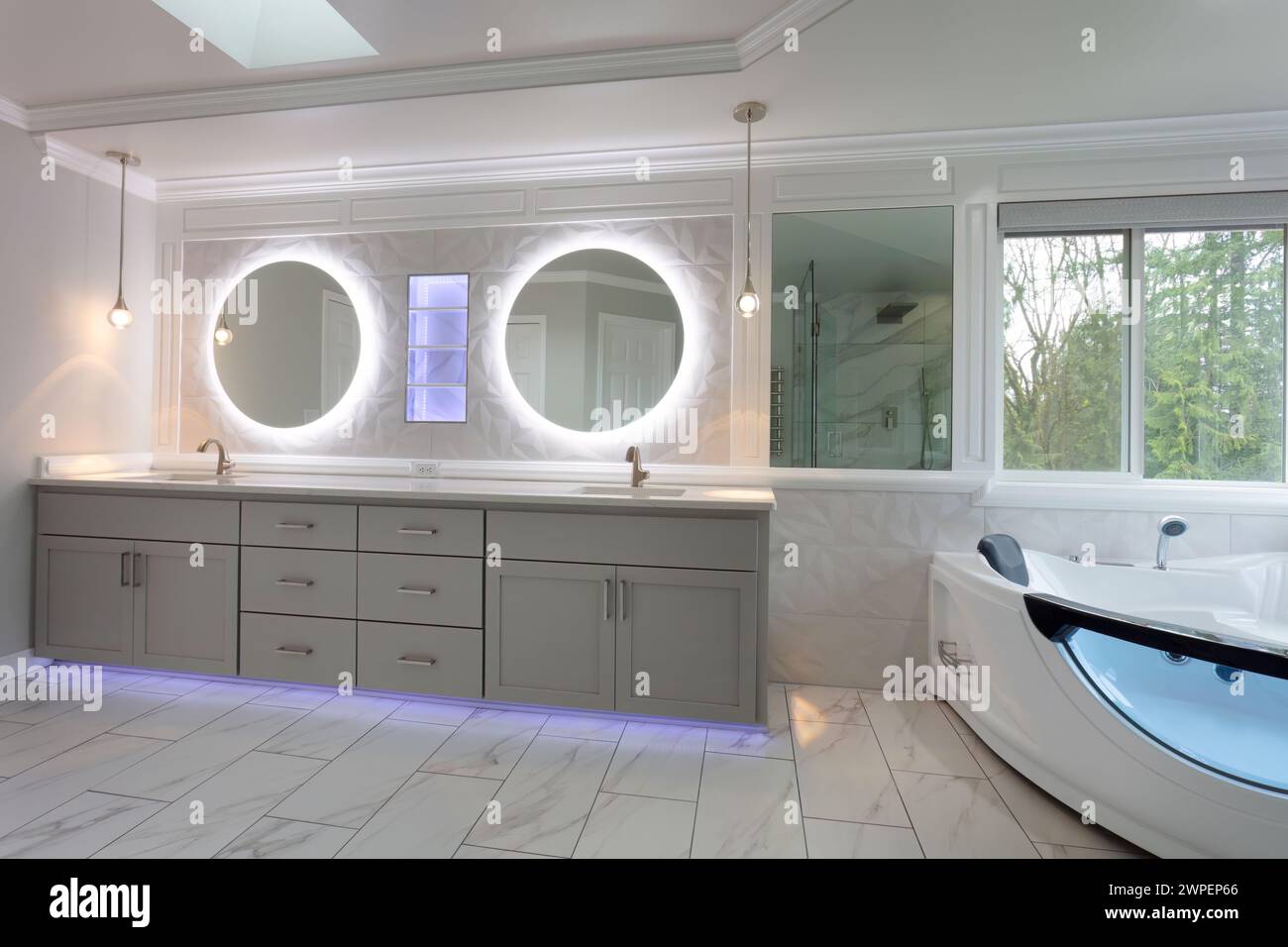 Spacious modern contemporary master bathroom with remodel of vanity and wall plus shelf with lights Stock Photo