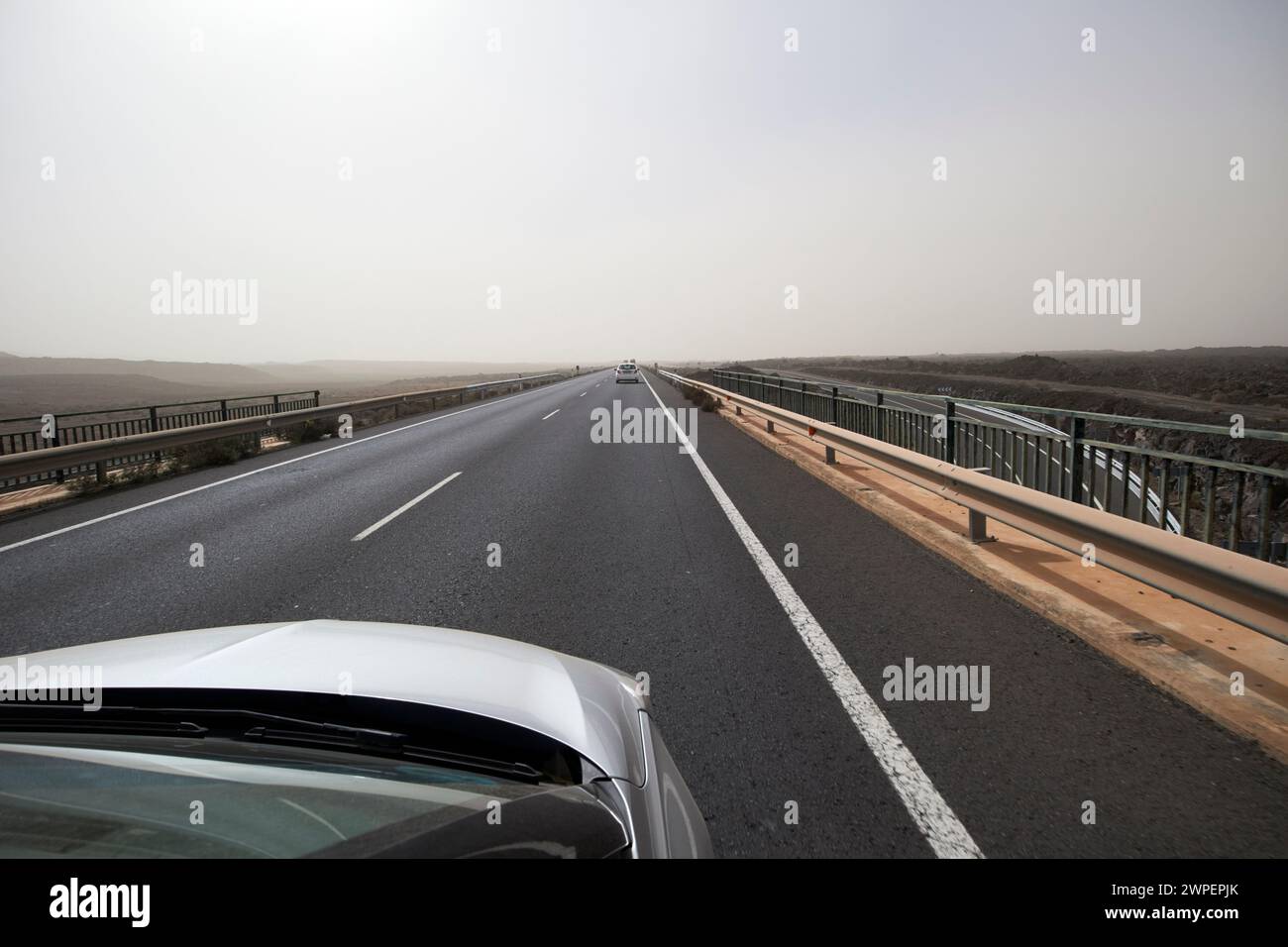 driving along the lz-2 road towards playa blanca during a calima dust storm, Lanzarote, Canary Islands, spain Stock Photo
