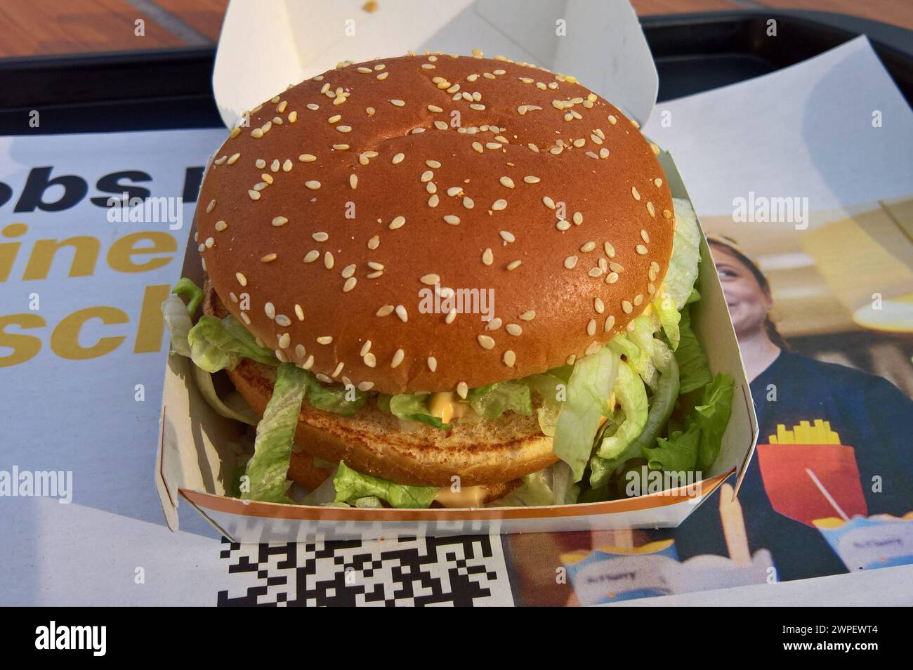 Der Big Mac, in Deutschland früher auch als Big Mäc bezeichnet, ist eine doppelstöckige Cheeseburger-Variante des Fast-Food-Konzerns McDonald. Die McDonalds Corporation ist ein US-amerikanischer Betreiber und Franchisegeber von weltweit vertretenen Schnellrestaurants und der umsatzstärkste Fastfood-Konzern der Welt *** The Big Mac, formerly known as the Big Mäc in Germany, is a double-decker cheeseburger variant of the McDonalds fast food group The McDonalds Corporation is an American operator and franchisor of fast food restaurants worldwide and the worlds highest-selling fast food group Stock Photo