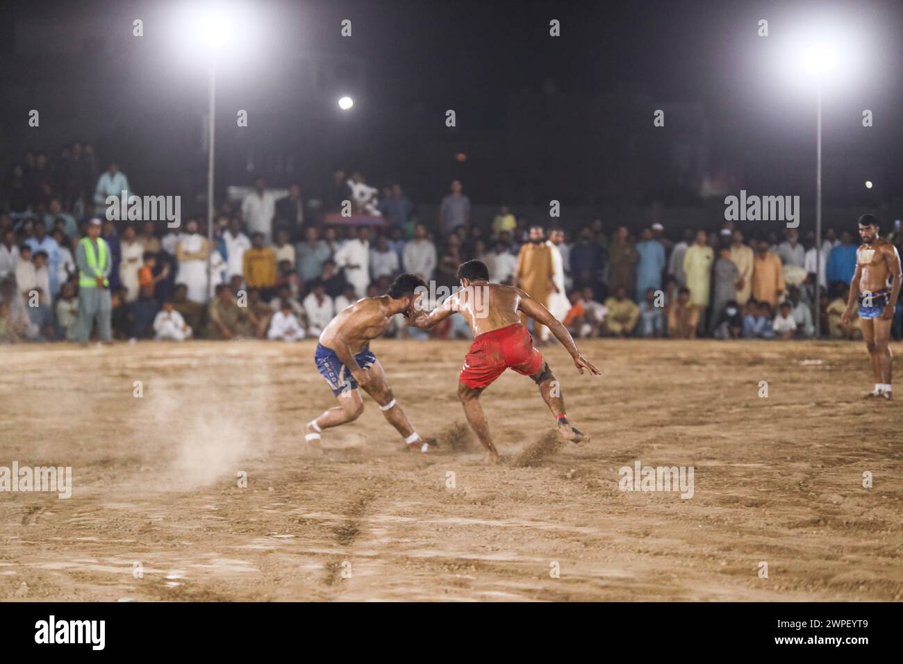 kabaddi match. Kabaddi players chasing raids against team in crowded stadium. Kabaddi Punjab Sports Stock Photo