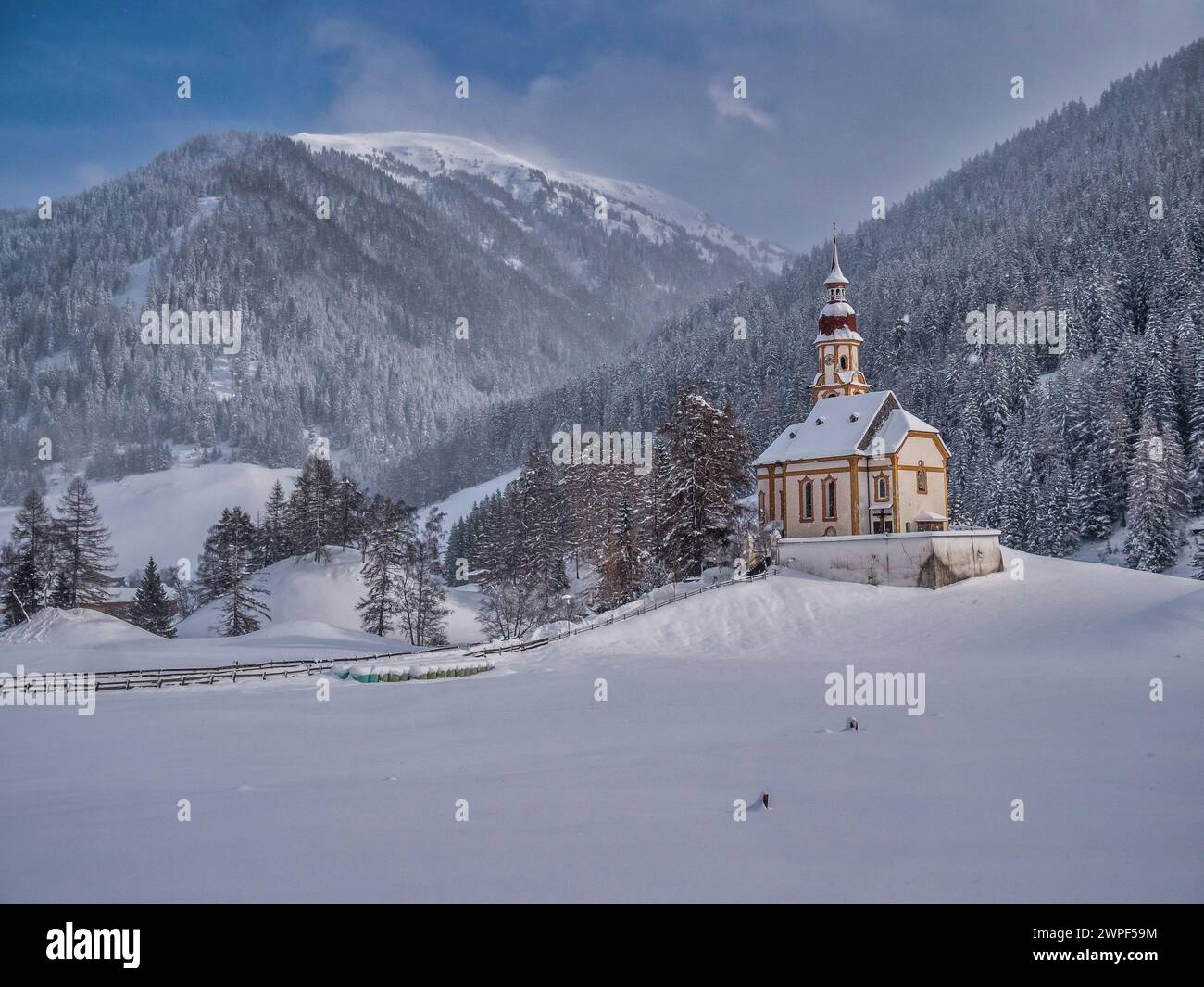 This winter image is of St Nicholas's Church located in the village of Obernberg at the head of the Obernbergtal valley in the Austrian Tirol Stock Photo