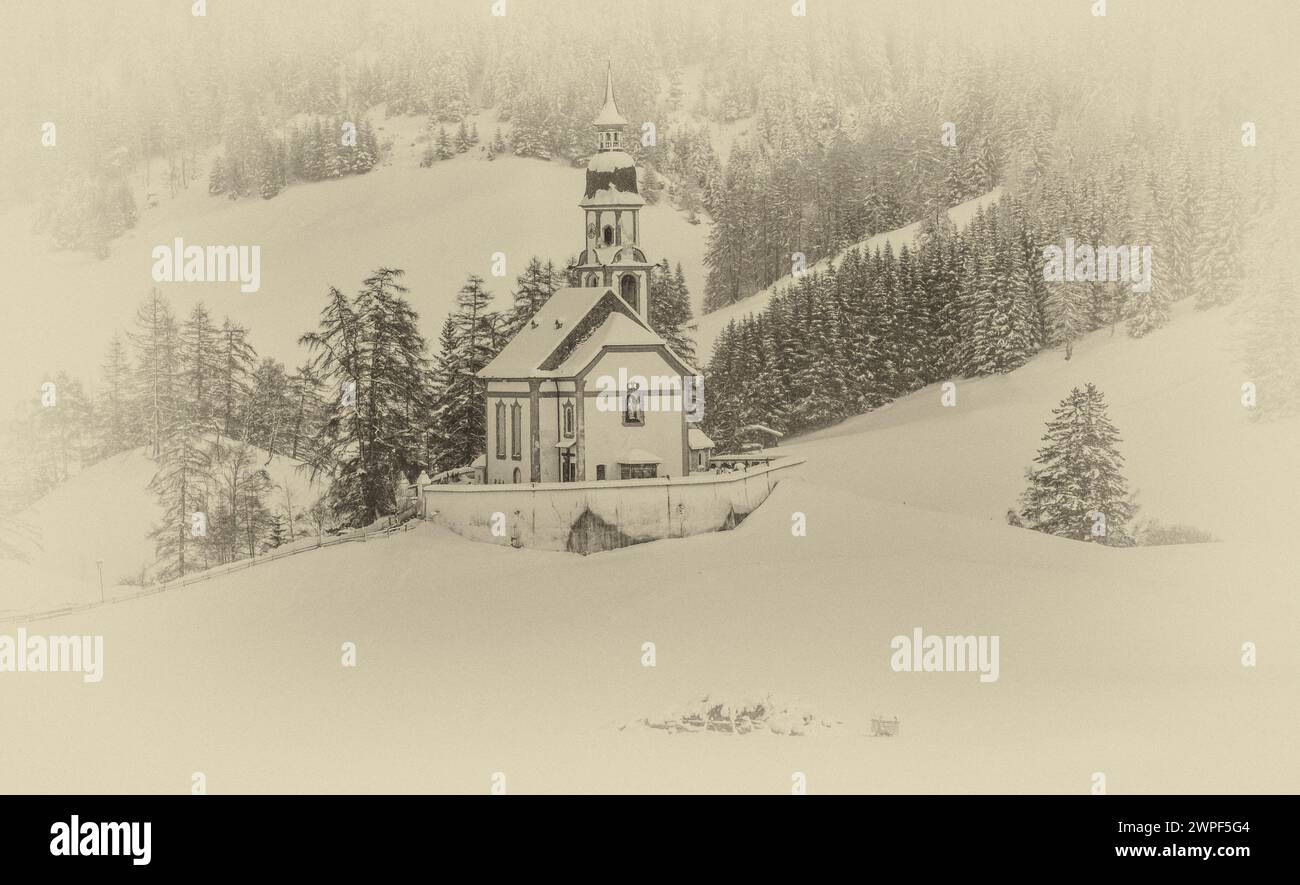 This winter image is of St Nicholas's Church located in the village of Obernberg at the head of the Obernbergtal valley in the Austrian Tirol Stock Photo