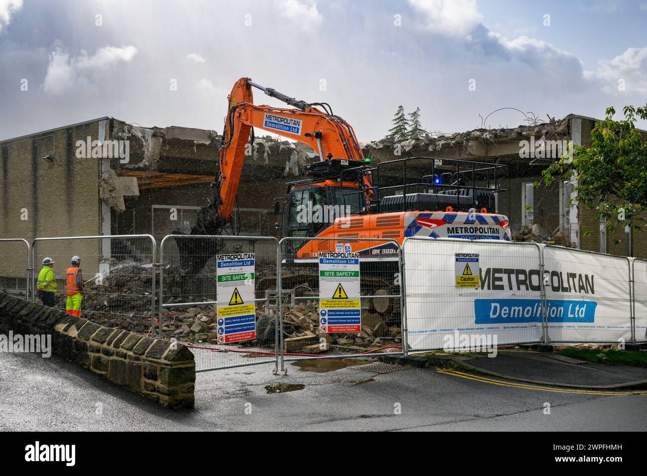 Demolition site (rubble, heavy machinery, building deconstruction, controlled collapse, empty shell) - Baildon library, West Yorkshire, England, UK. Stock Photo