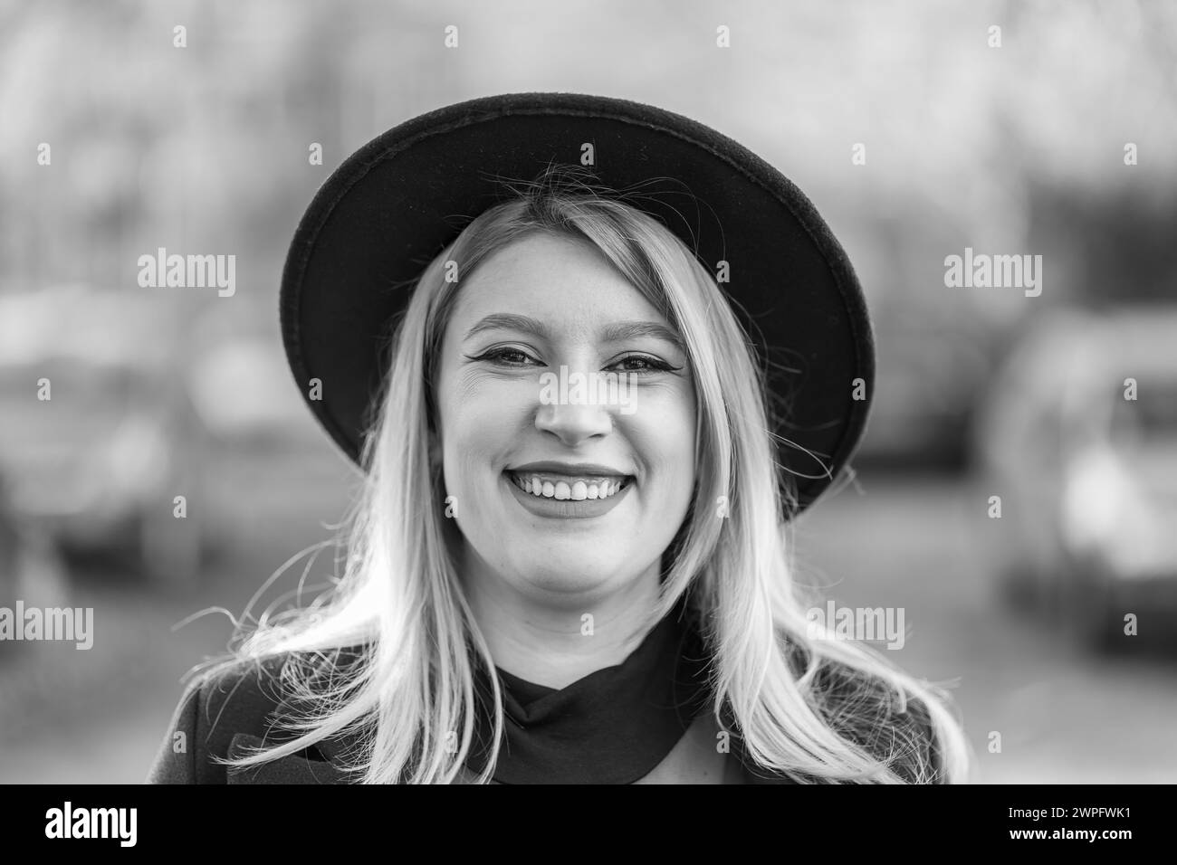 Close-up portrait of a young woman with a black hat. Black and white. Stock Photo