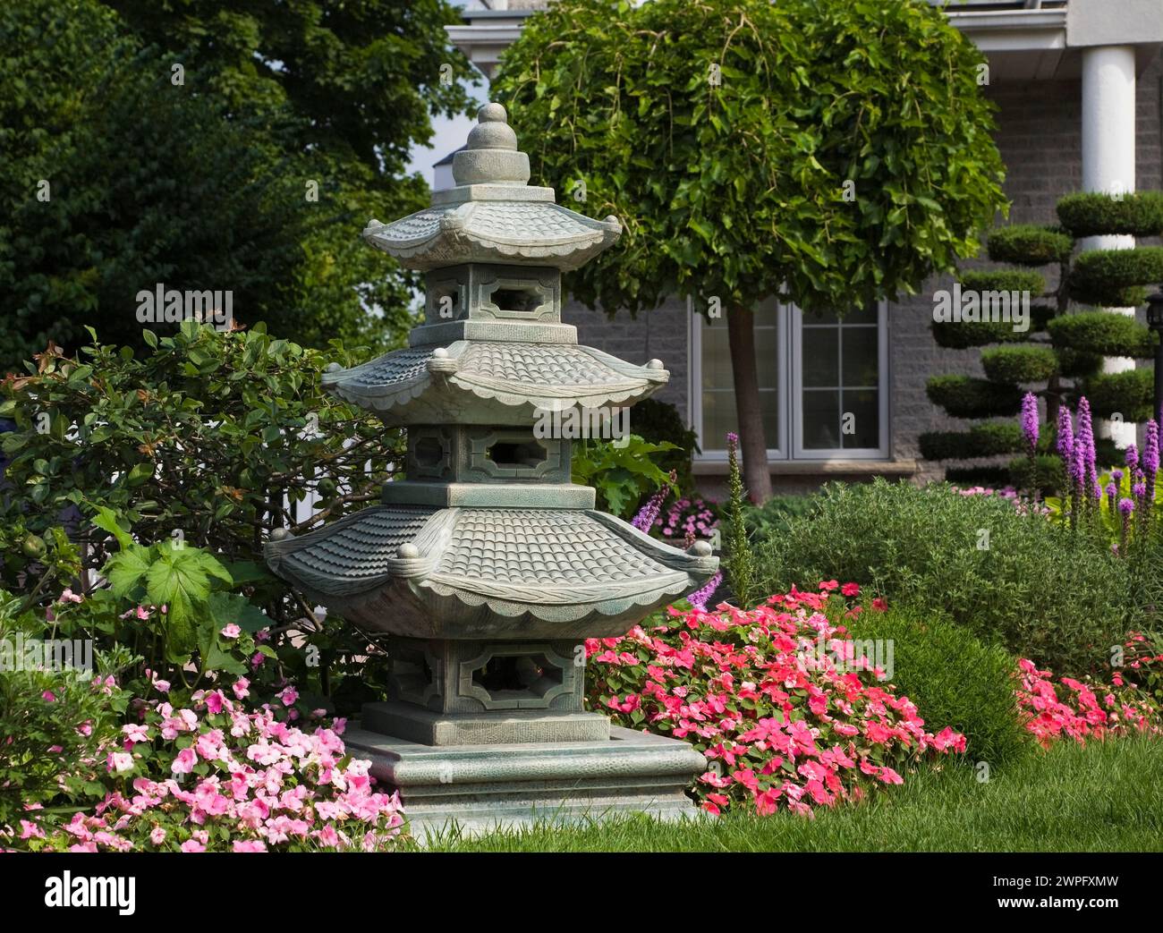 Pink and red Impatiens - Balsam flowers and pagoda in border in ...