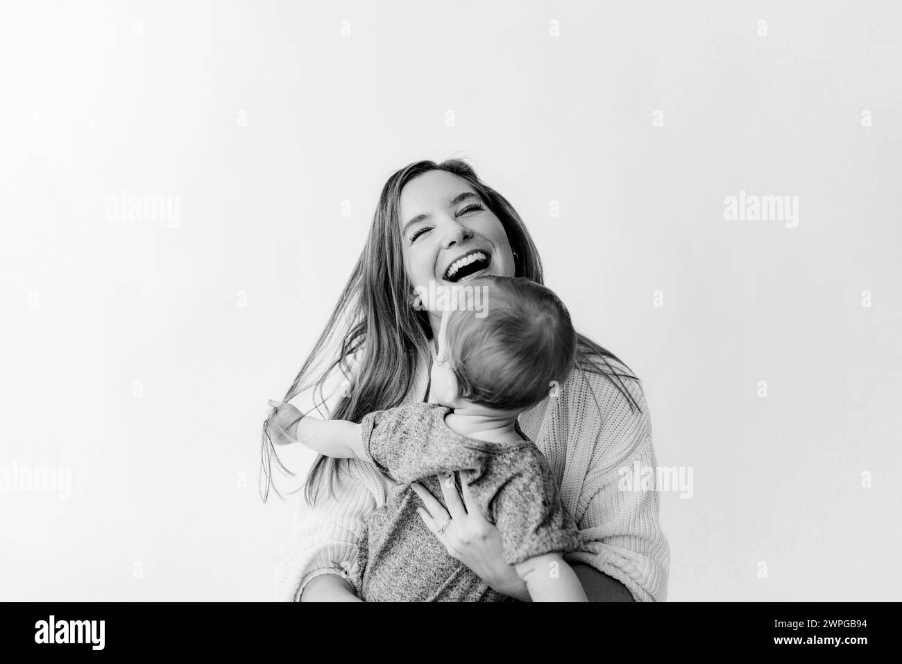 Mom and son, motherhood, child pulling mom's hair, love hurts. Stock Photo