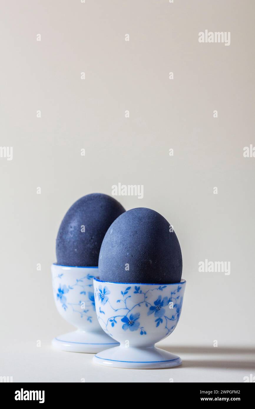 Eggs colored with wine in an egg cup on a light background. Easter concept. Stock Photo