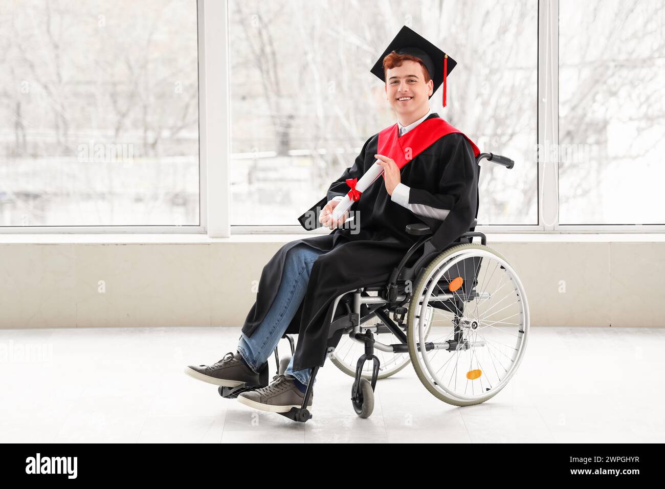 Male graduate in wheelchair with diploma at university hall Stock Photo ...