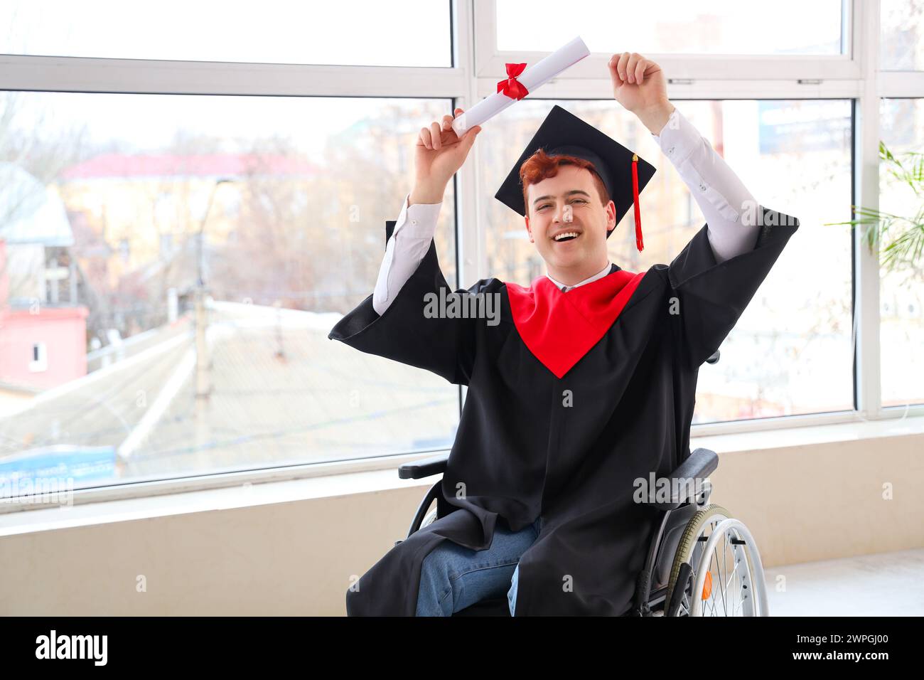 Male graduate in wheelchair with diploma at university hall Stock Photo ...