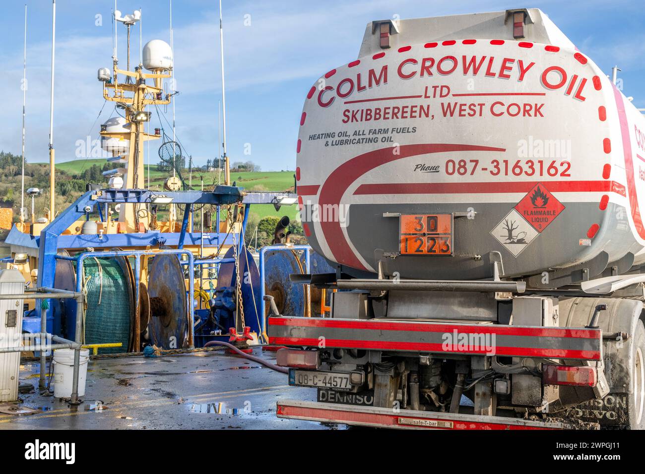 Fishing trawler refuelled by fuel lorry at Keelbeg Pier, Union Hall, West Cork, Ireland. Stock Photo