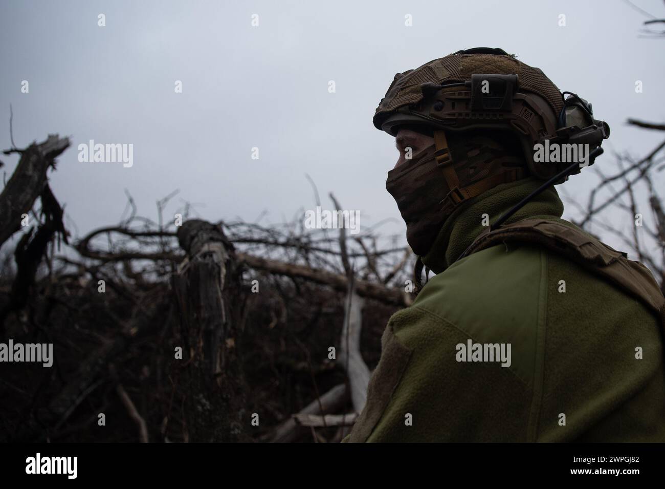 Kyiv, Donetsk Oblast, Ukraine. 7th Mar, 2024. Vlad, a Ukrainian solider, sits inside a Ukrainian trench looking towards Russian lines. Russian infantry positions are 100m away from Ukrainian lines. (Credit Image: © Madeleine Kelly/ZUMA Press Wire) EDITORIAL USAGE ONLY! Not for Commercial USAGE! Stock Photo