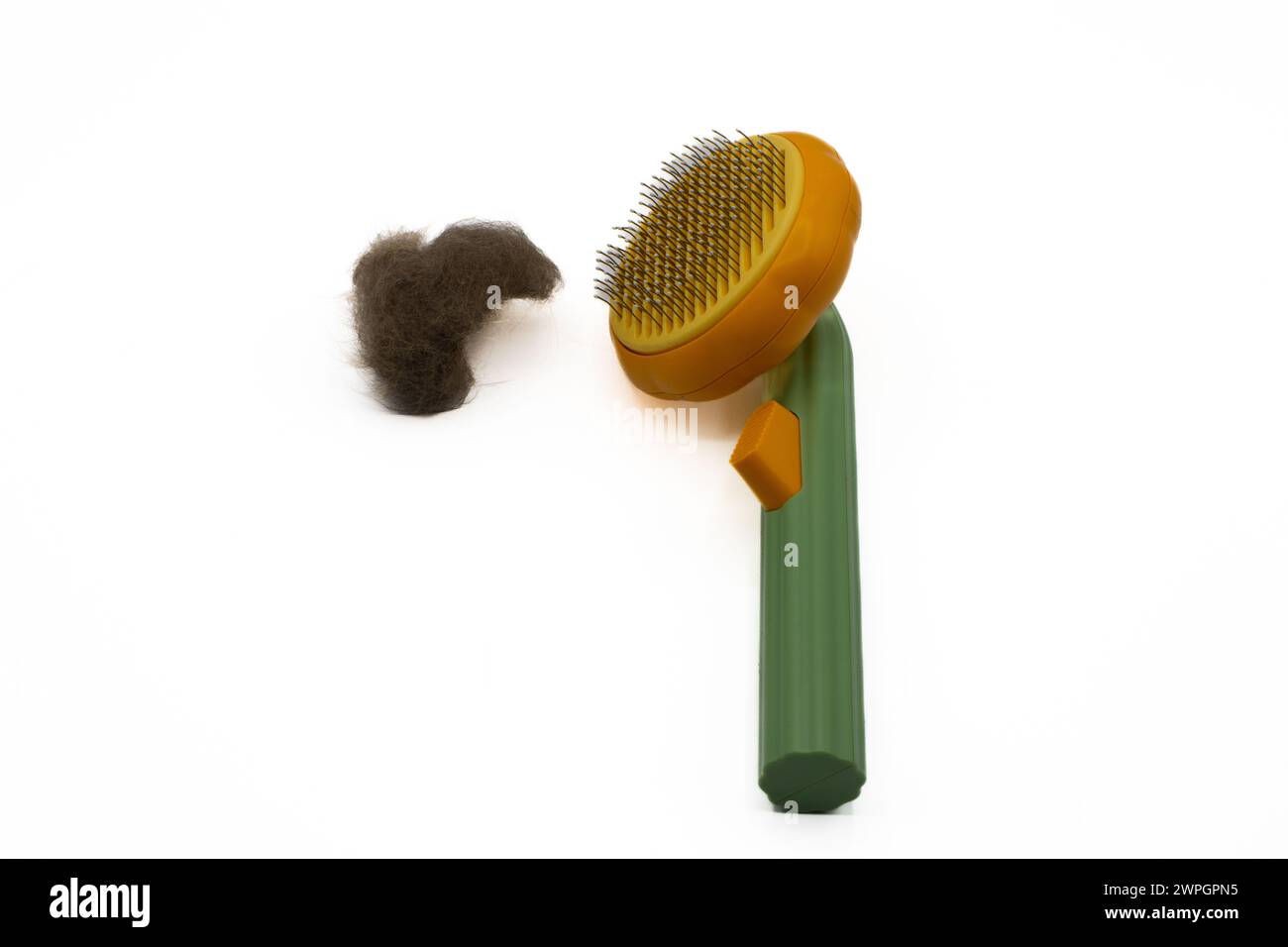 Cat hair brush with tuft of cat fur next to it Stock Photo