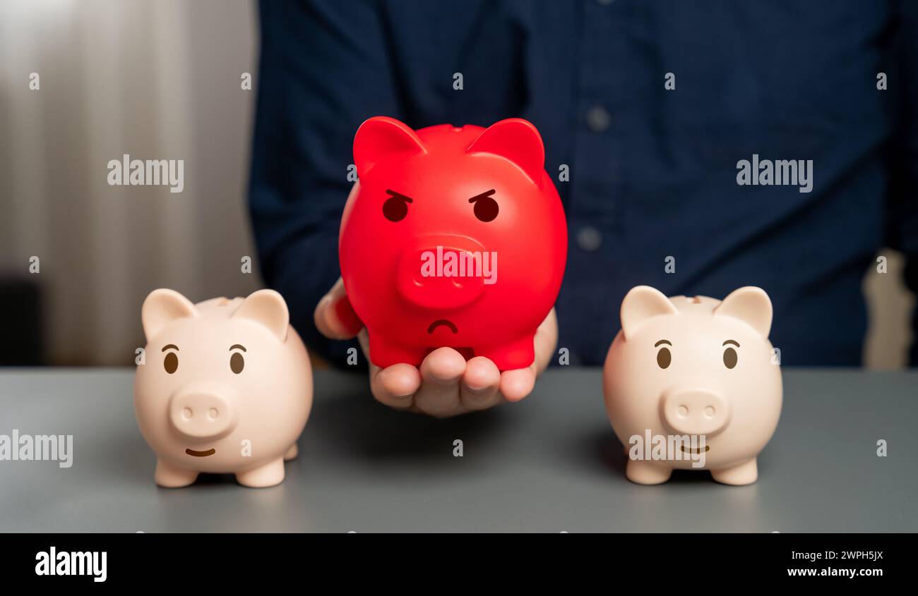 Red bloated piggy bank against the background of normal ones. Overheated financial market. Oversaturation of funds and acceleration of inflation. Heav Stock Photo