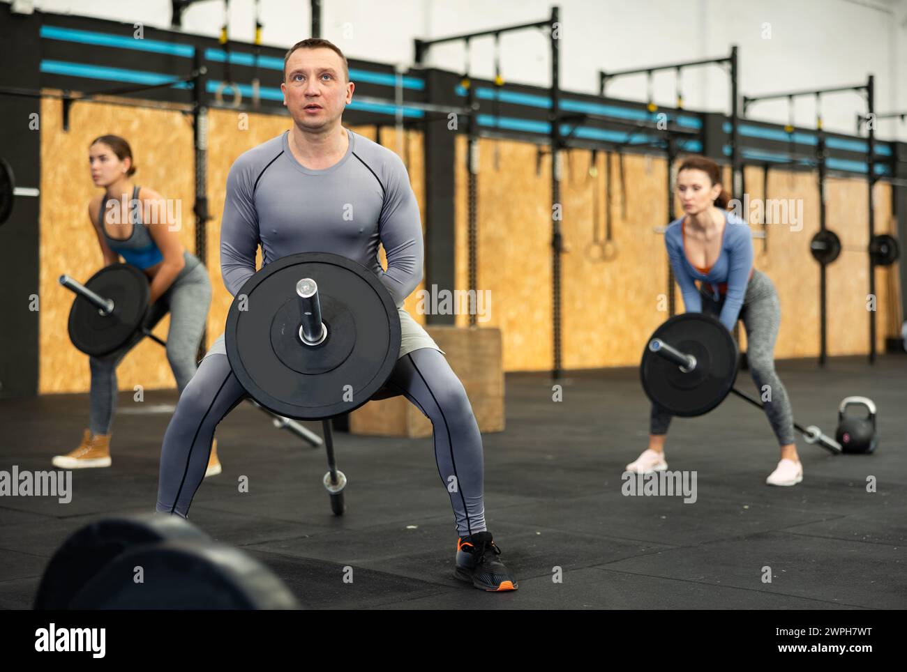 Concentrated middle-aged man performing T-Bar row at gym Stock Photo