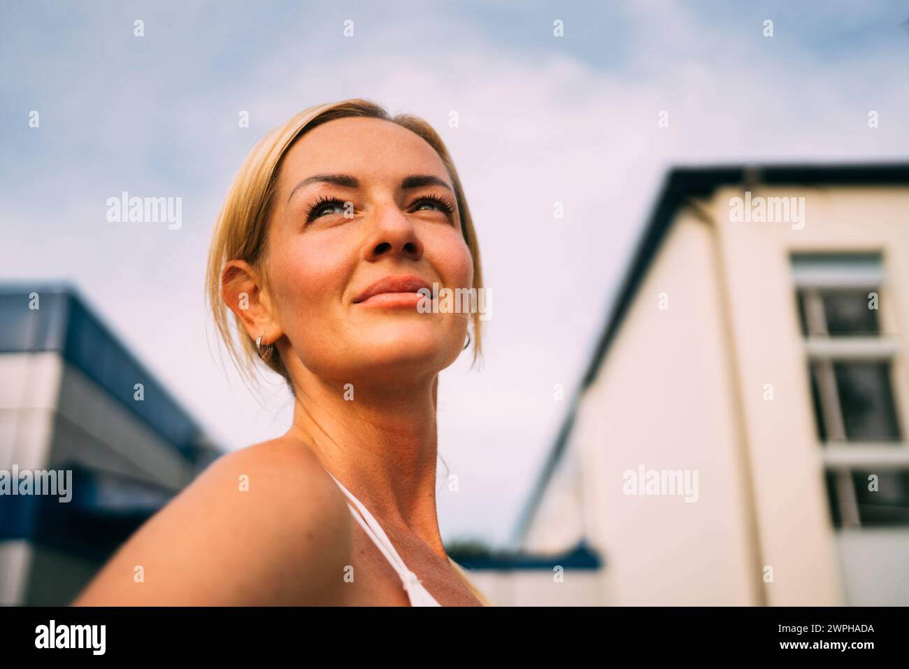 Beautiful blonde woman portrait outdoors in sportswear doing workout ...