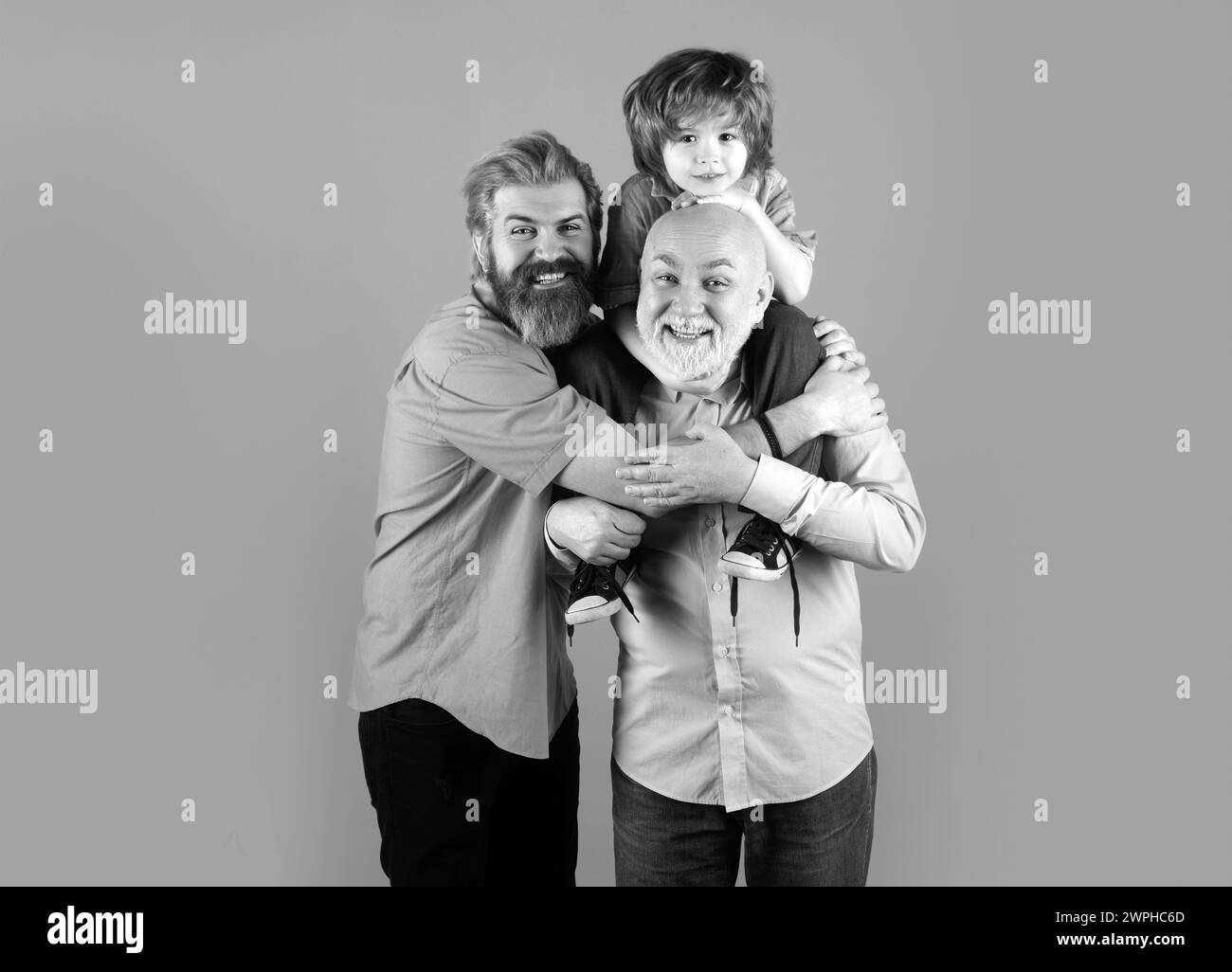 Grandfather father and son grandson hugging and embracing. Fathers day concept. Men in different ages cuddling bonding. Parenthood with grand parent Stock Photo