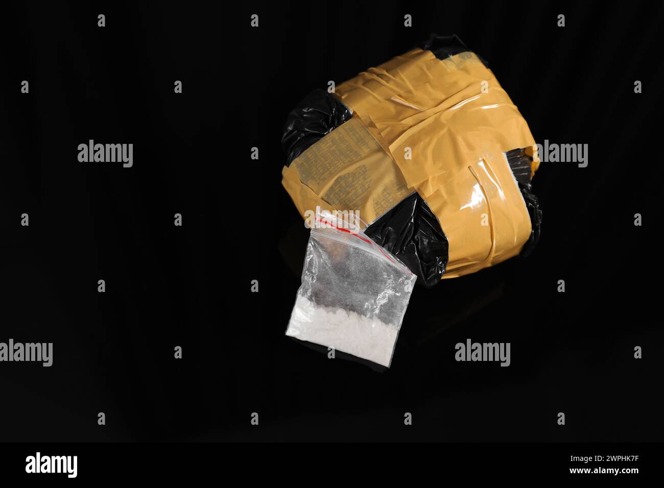 Smuggling and drug trafficking. Packages with narcotics on black surface, space for text Stock Photo