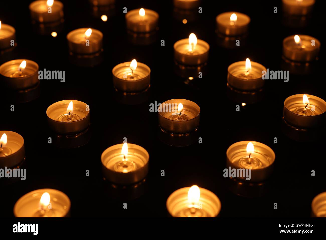 Burning candles on mirror surface in darkness Stock Photo - Alamy