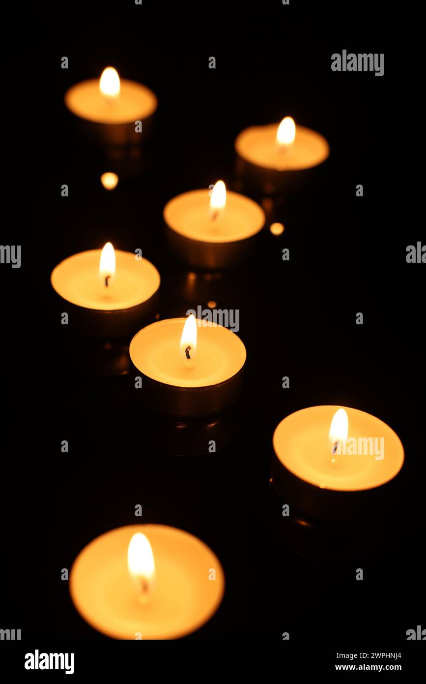 Burning candles on mirror surface in darkness Stock Photo - Alamy