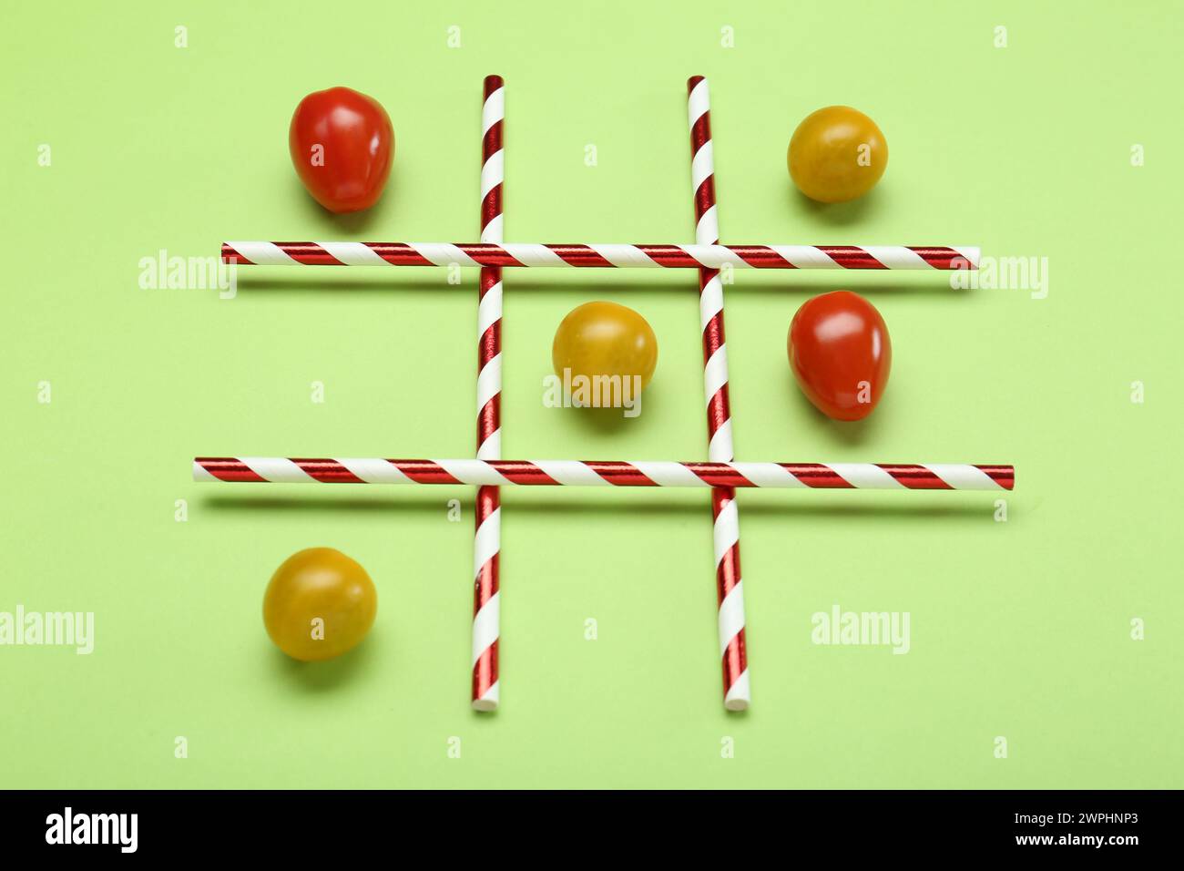 Tic tac toe game made with cherry tomatoes on light green background Stock Photo