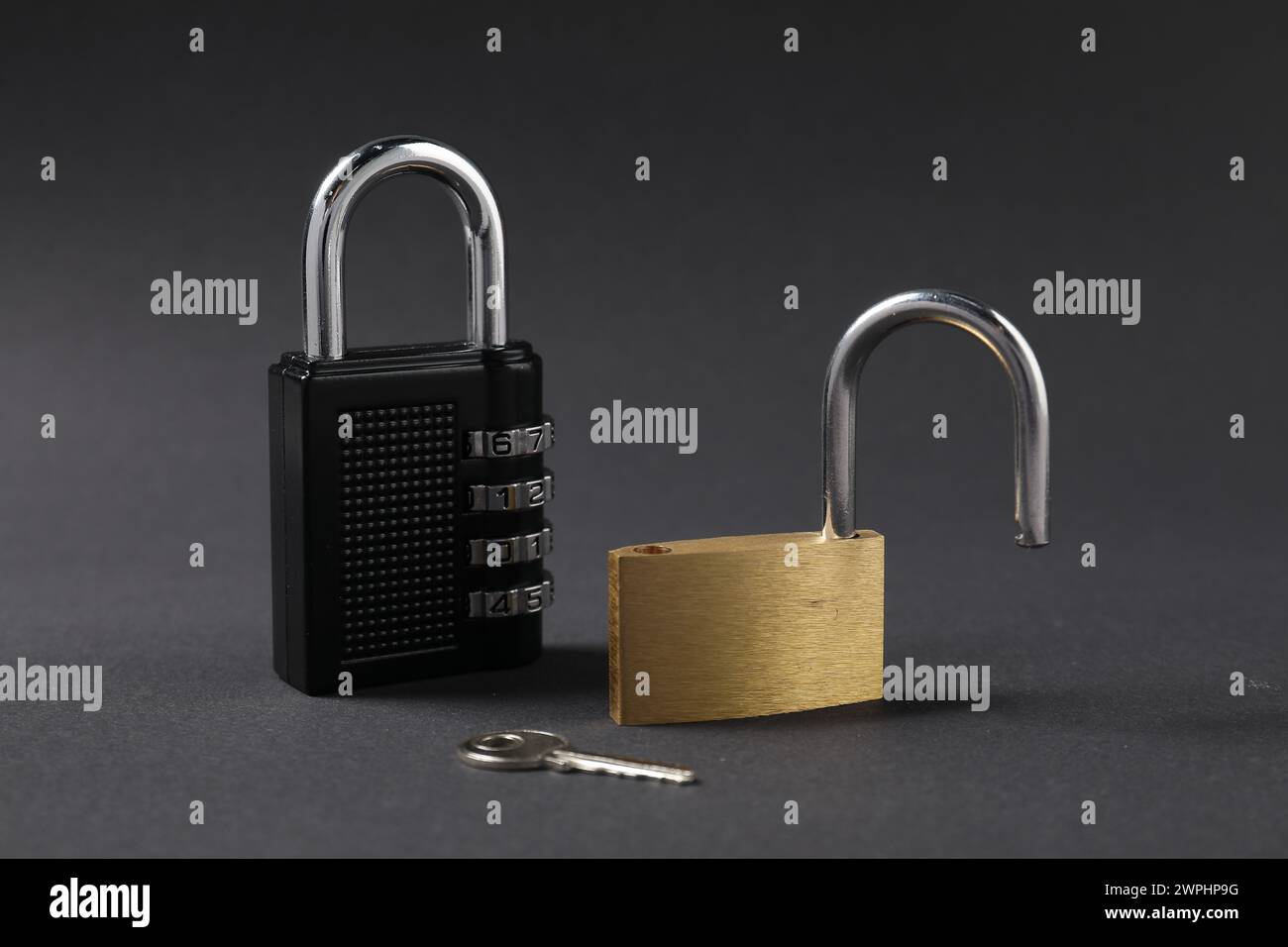 Different padlocks and key on black background, closeup Stock Photo