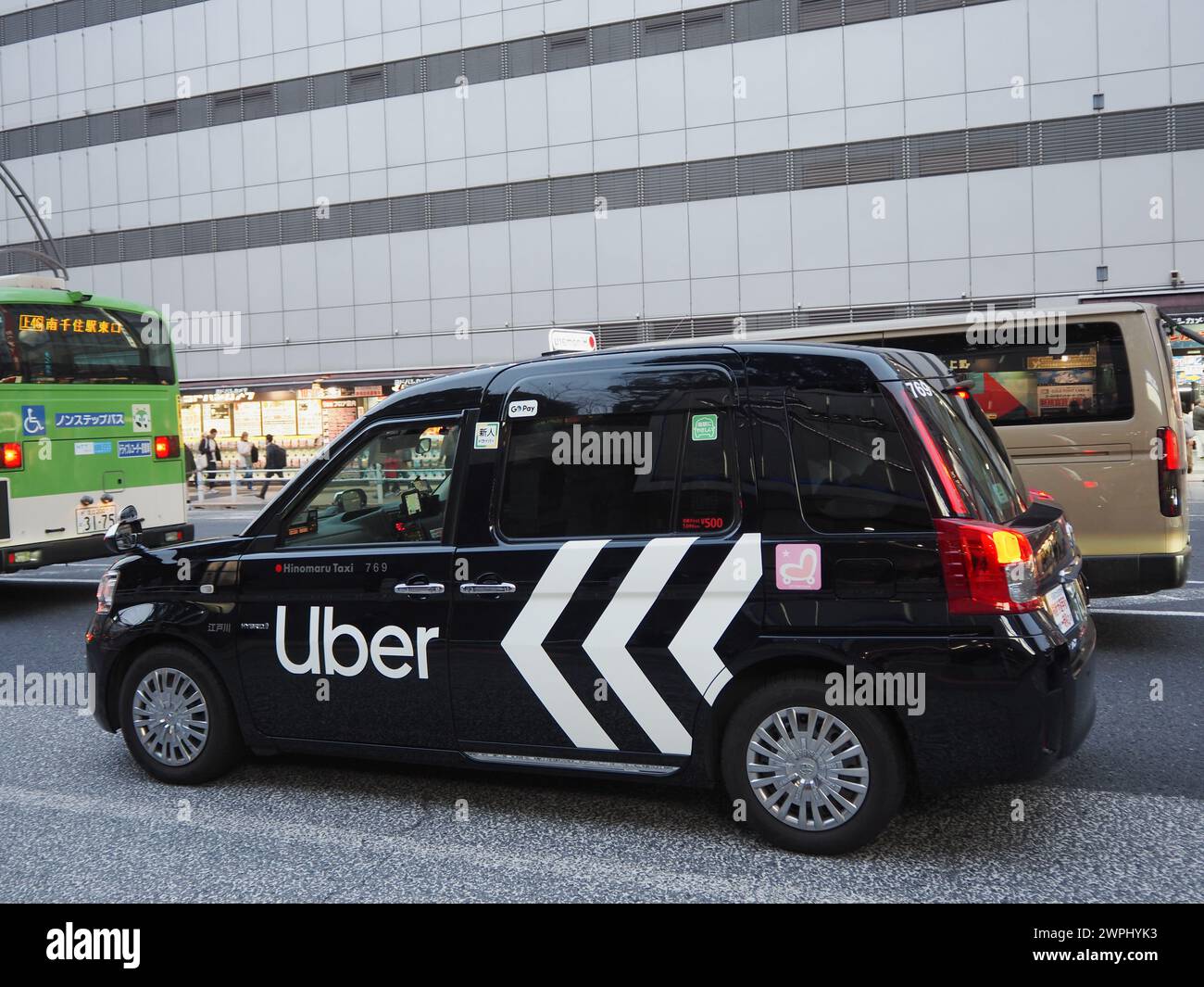 TOKYO, JAPAN - February 14, 2024: An Uber Taxi in traffic in Tokyo's Ueno area. Stock Photo