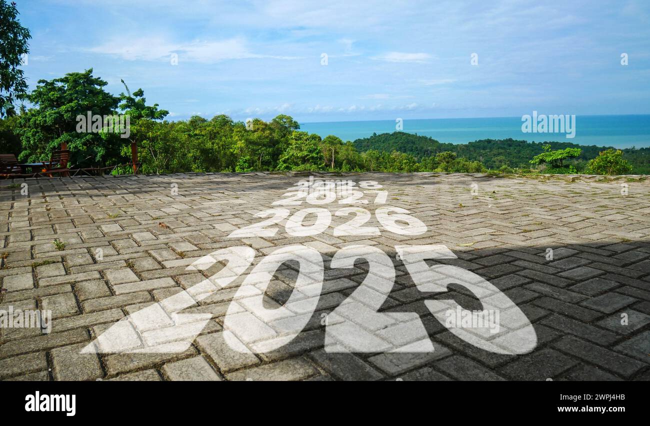 The years 2025 to 2029 are written on the road at the top of the hill with a view of the blue