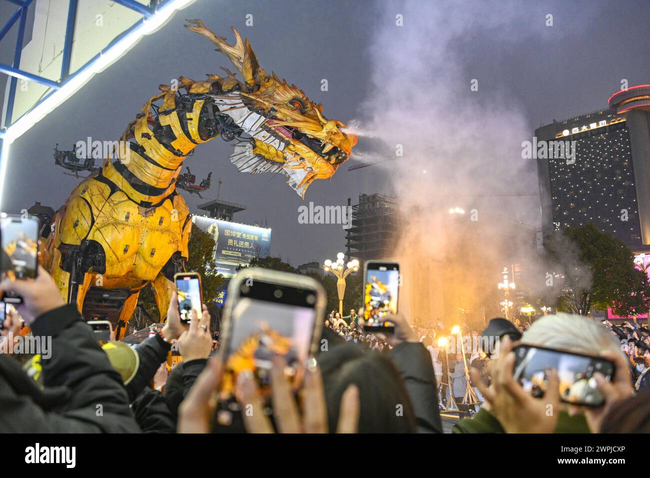 People watch the farewell performance of a large mechanical