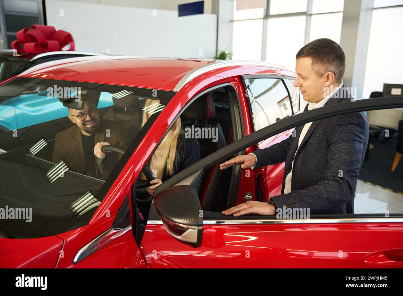 Two people talking to a car salesman Stock Photo Alamy