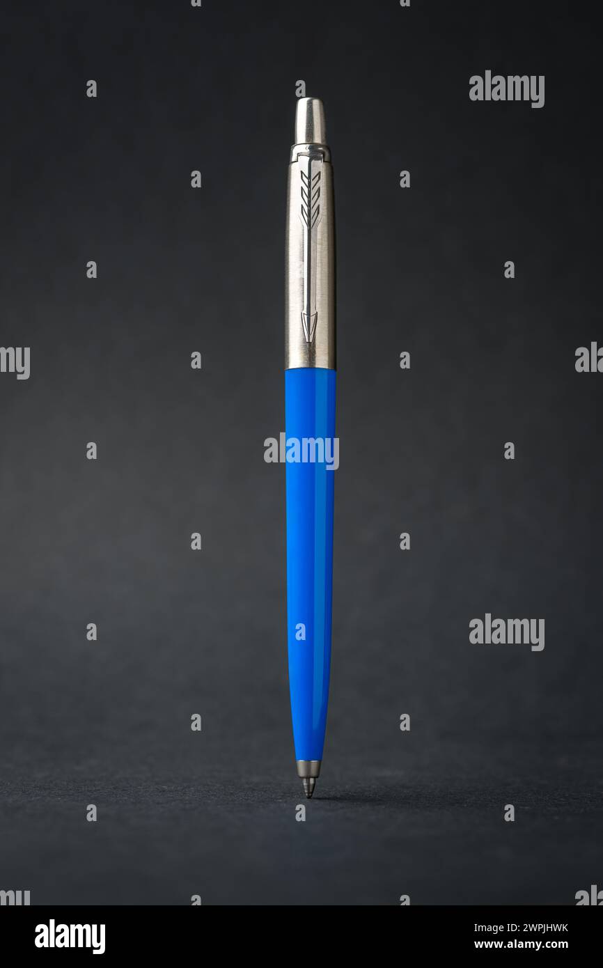 Blue plastic and metal ballpoint pen on dark gray background Stock Photo