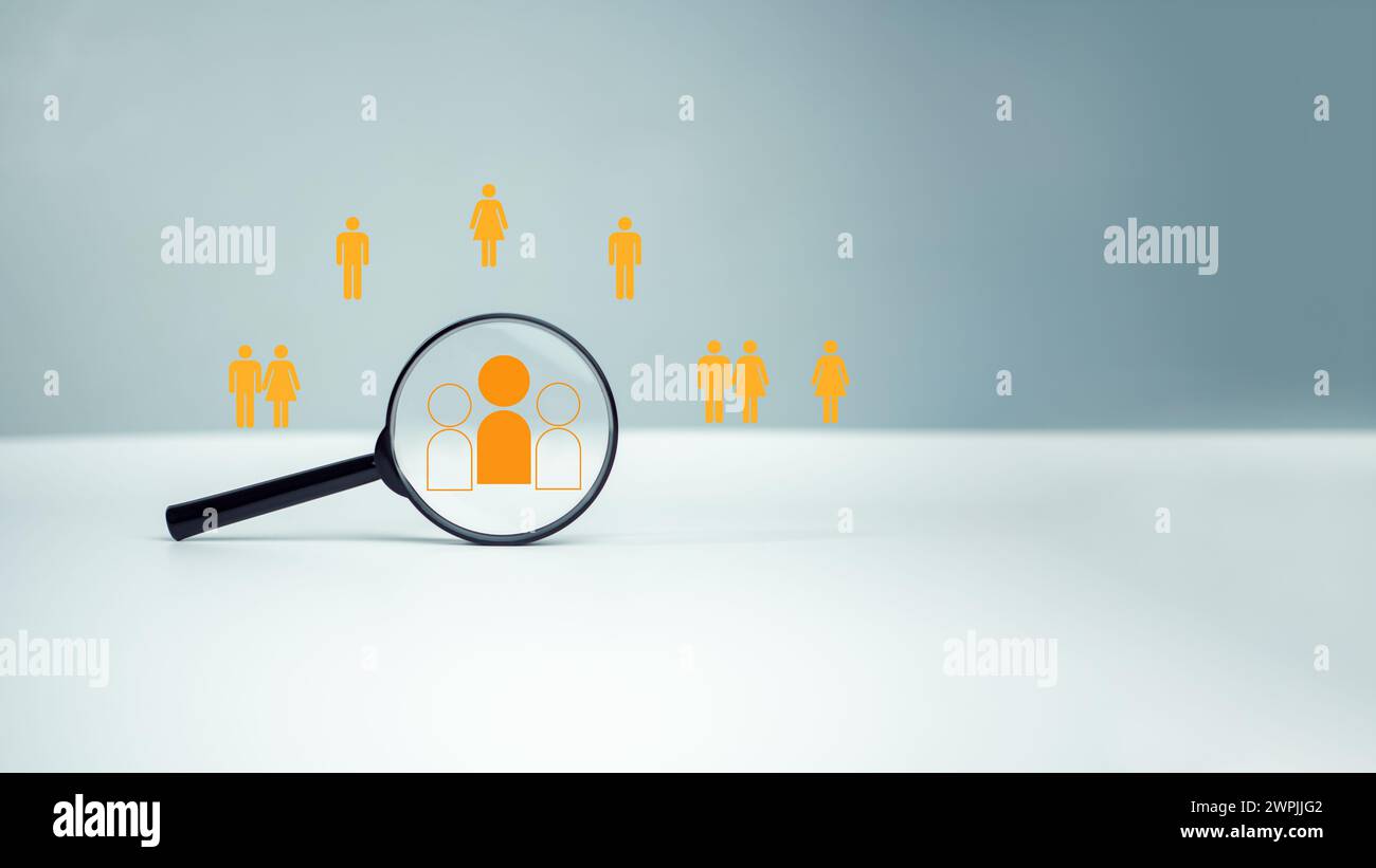 Customer group icons in a magnifying glass placed on a white background represent the selection of business goals, target customers, Marketing plans a Stock Photo