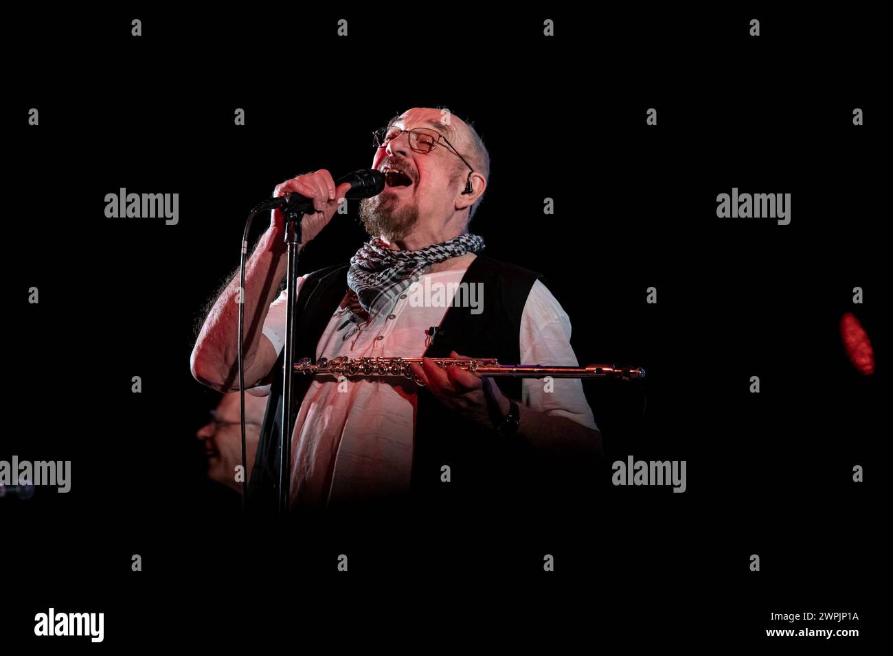 Ian Anderson is playing the flute on stage with his band Jethro Tull at